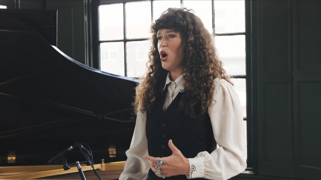 Singer performing in a waistcoat and blouse